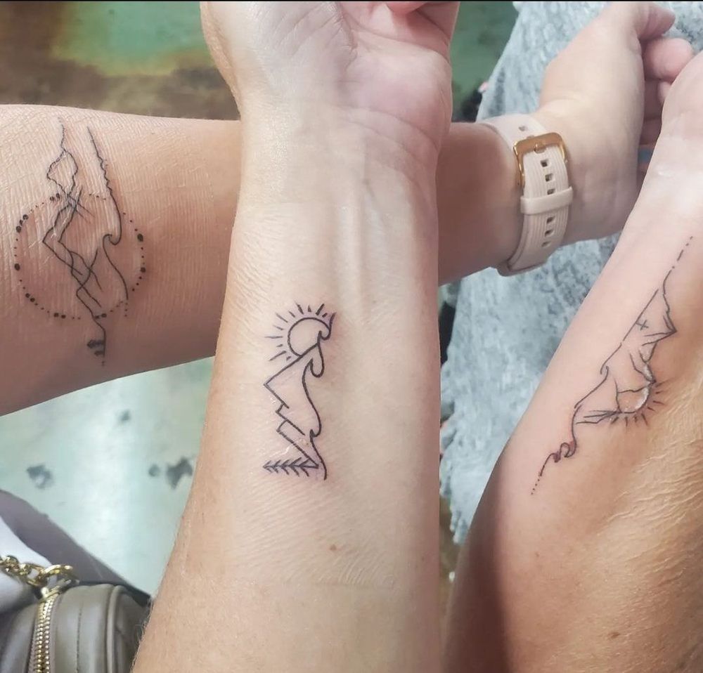 A couple of people with tattoos on their wrists