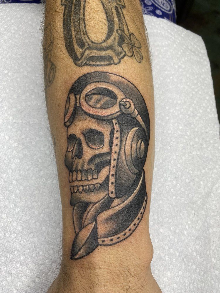 A tattoo of a skull wearing a helmet and goggles