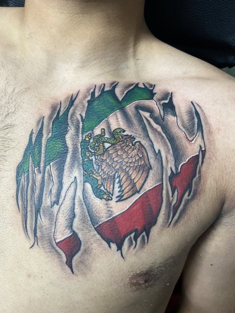 A man has a tattoo of the mexican flag on his chest