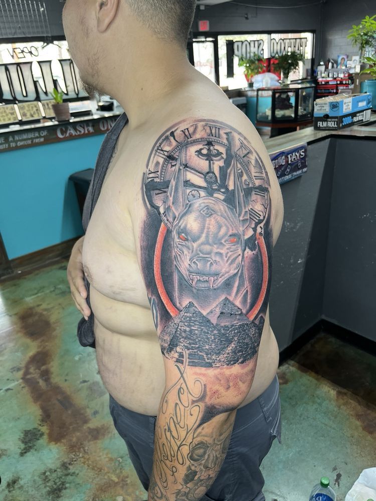 A man with a tattoo on his arm is standing in a room.