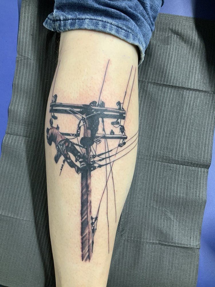 A person has a tattoo of a power line on their leg.