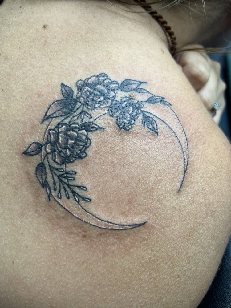 A woman has a tattoo of flowers on her back.