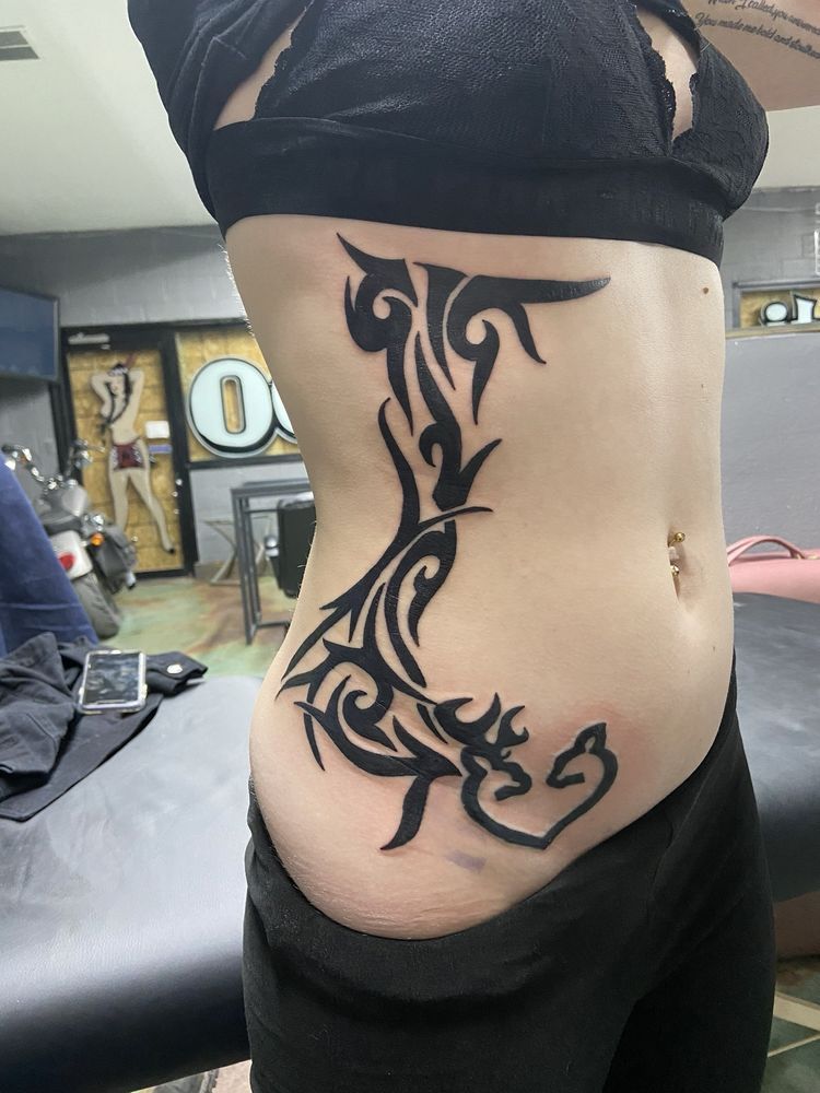 A woman has a tribal tattoo on her side