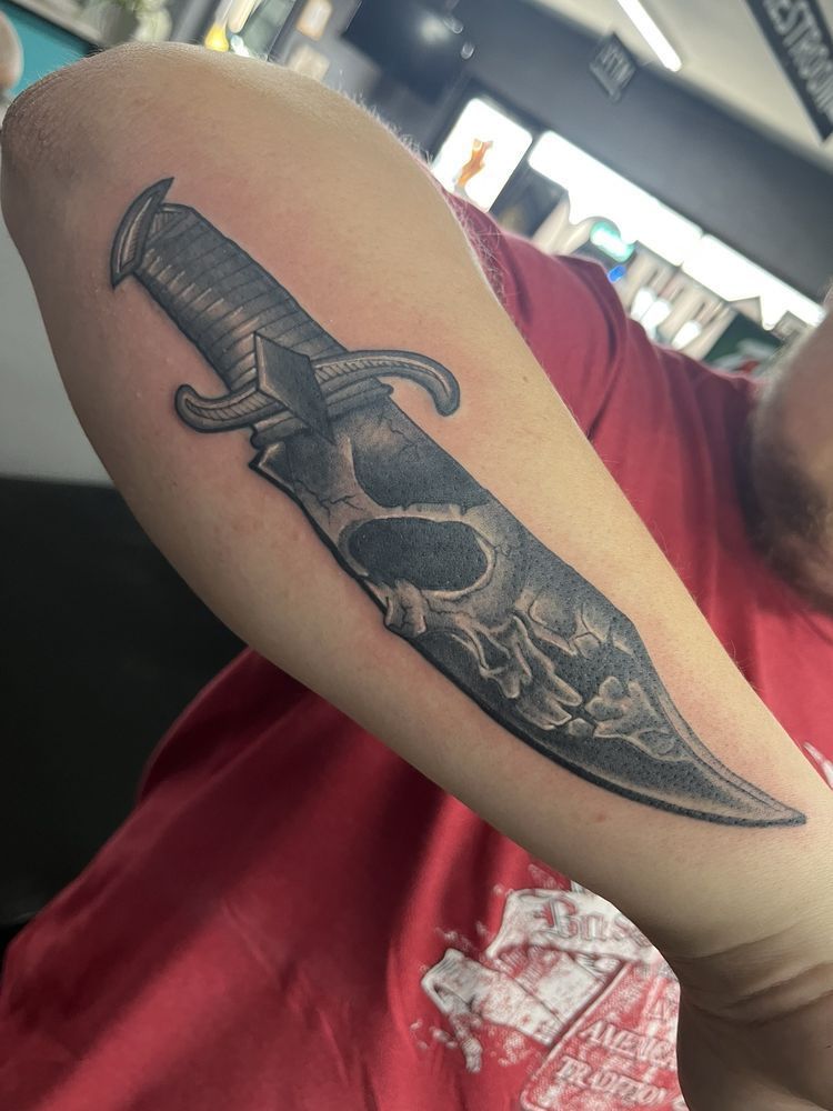 A person has a tattoo of a skull on their arm