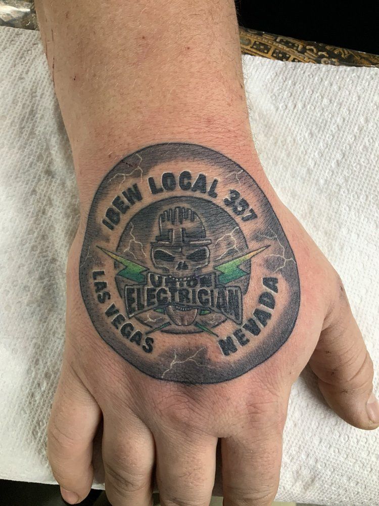 A close up of a person 's hand with a tattoo on it.