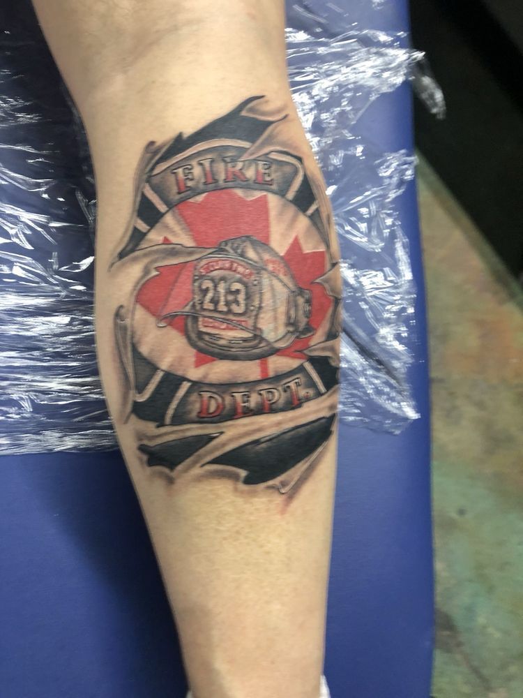 A tattoo of a fireman 's helmet with the number 213 on it