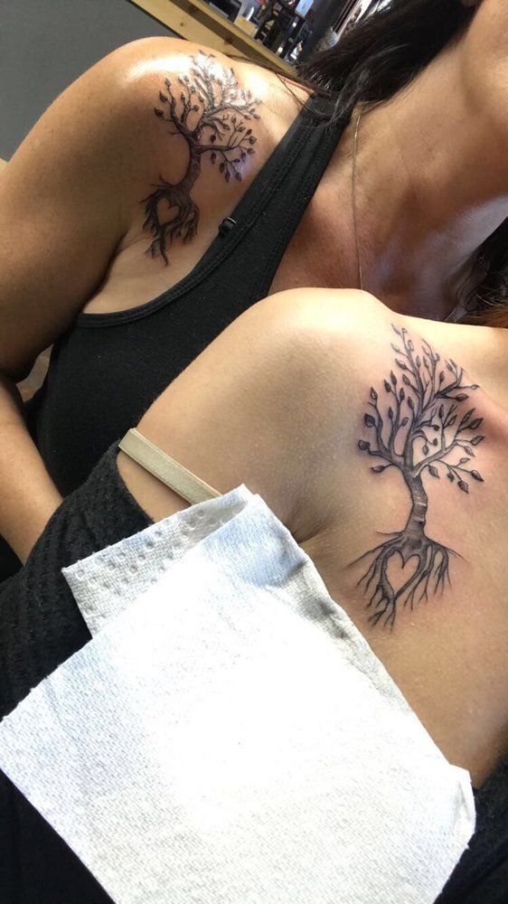 A woman has two tree tattoos on her shoulder.