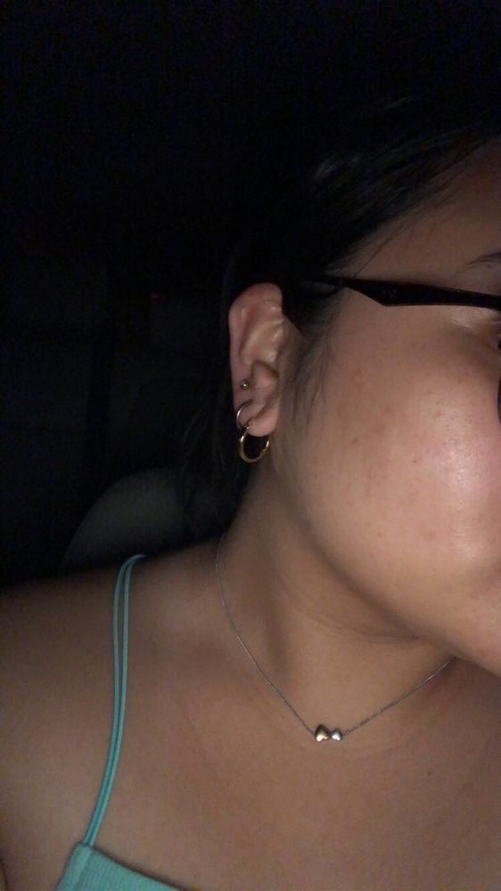 A close up of a woman wearing glasses and earrings.