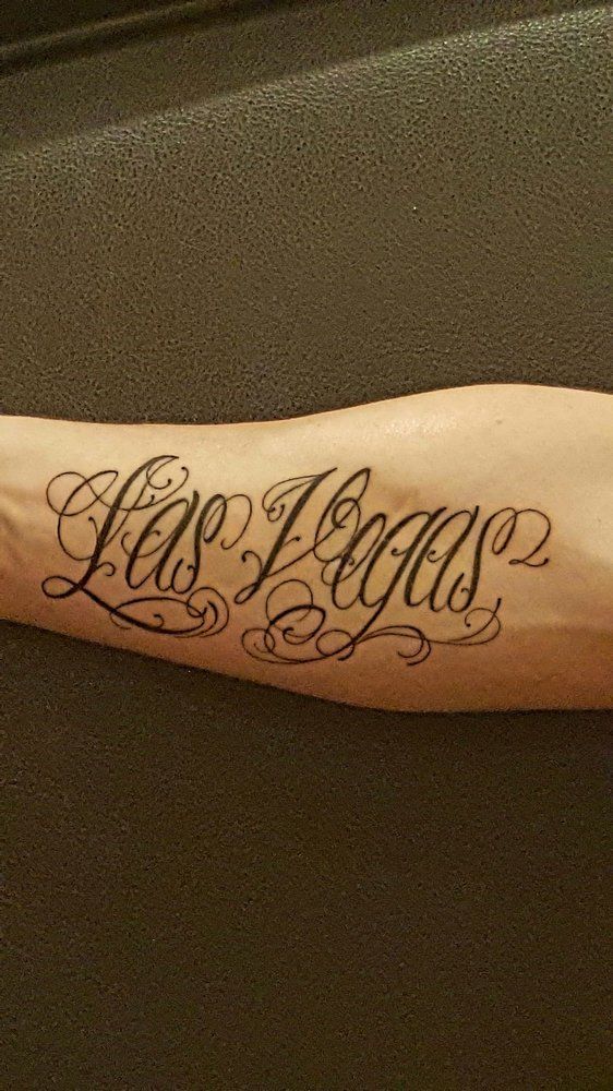 A person has a tattoo on their forearm that says las vegas.