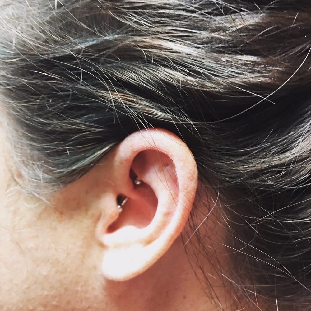 A close up of a woman 's ear with a piercing