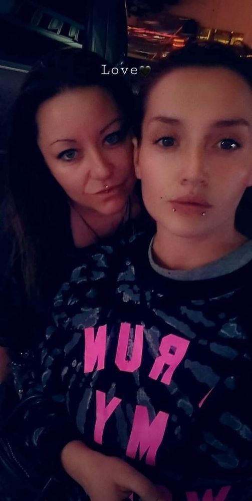 A woman and a girl are posing for a picture . the girl is wearing a shirt that says hua ym.