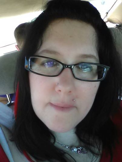 A close up of a woman wearing glasses and a necklace