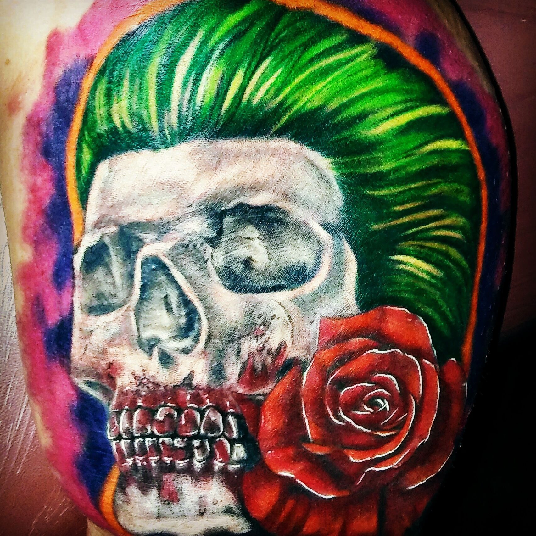 A tattoo of a skull with a rose in its mouth