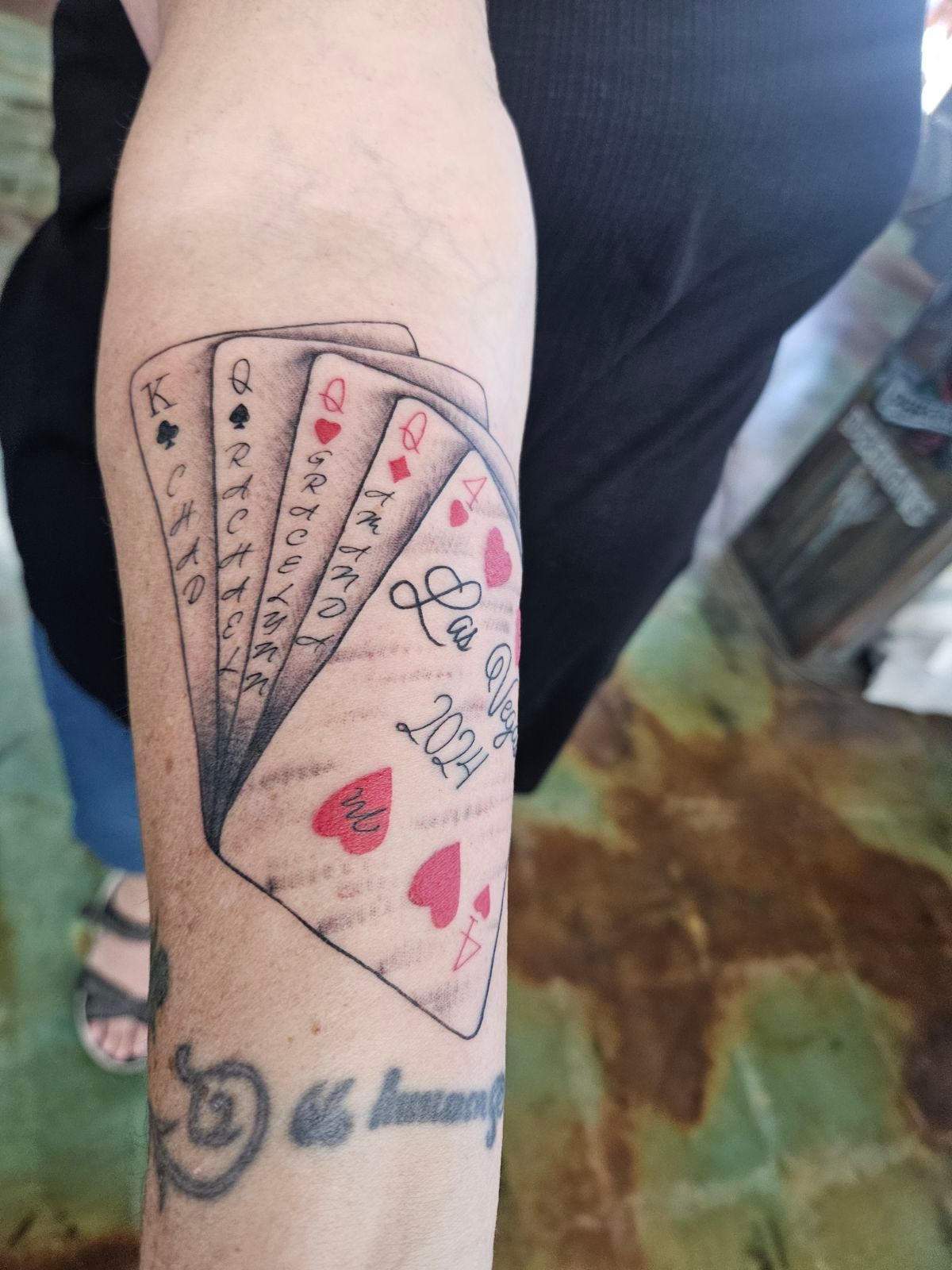 A person has a tattoo of playing cards on their arm