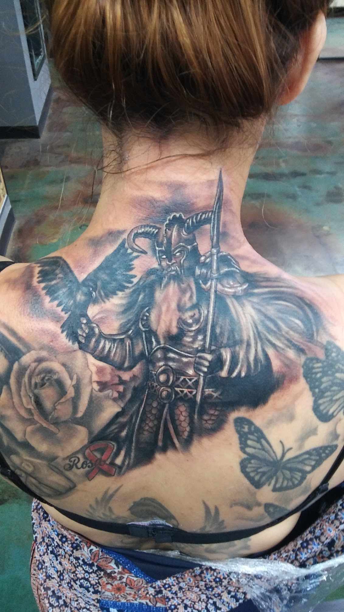 A woman has a tattoo of a warrior on her back.
