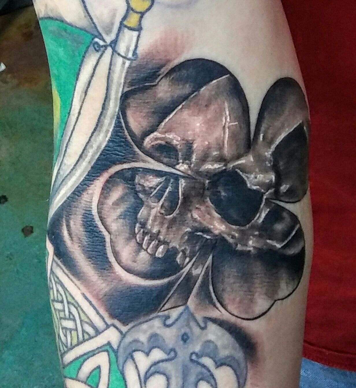 A person has a tattoo of a skull on their arm