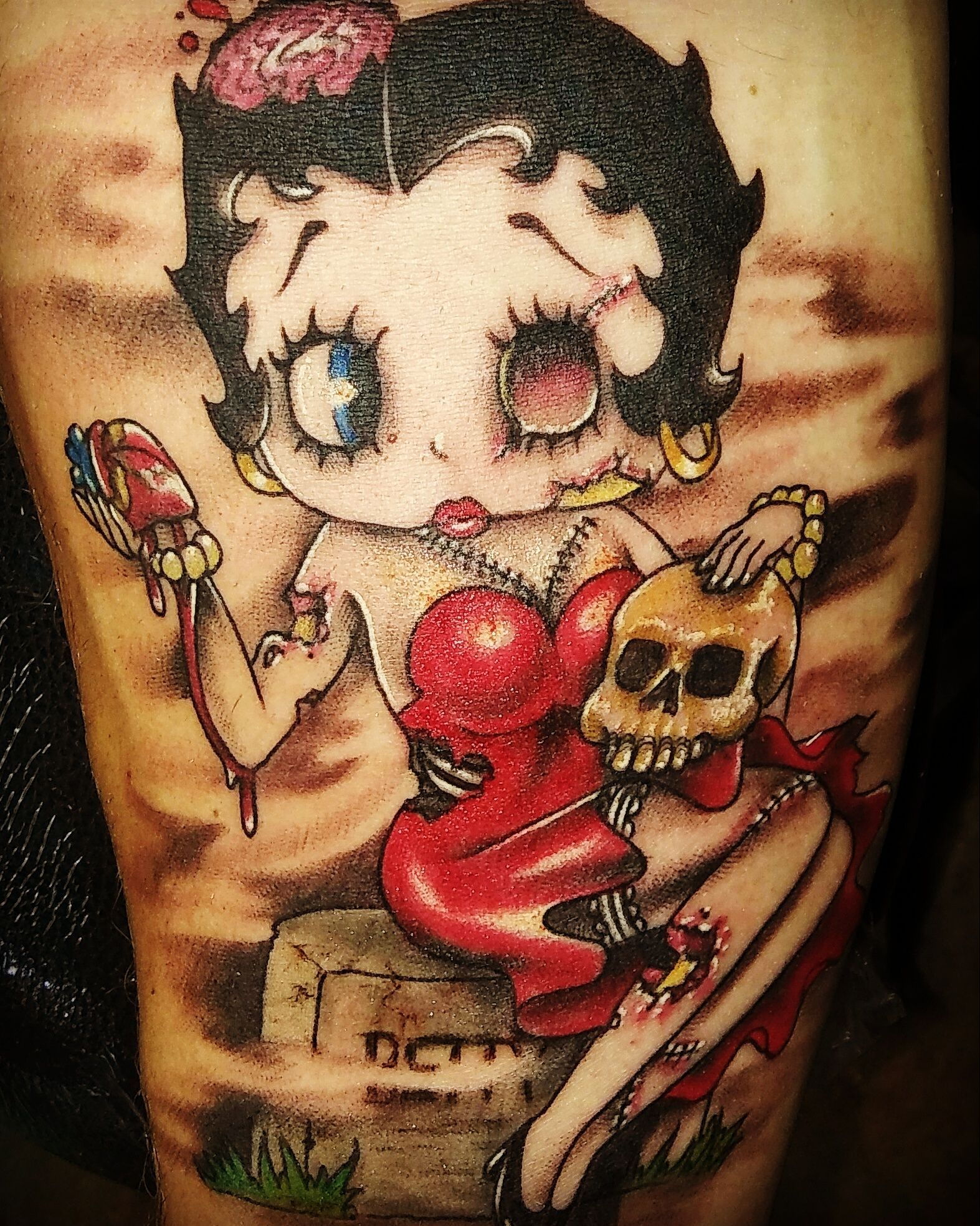 A tattoo of betty boop holding a skull