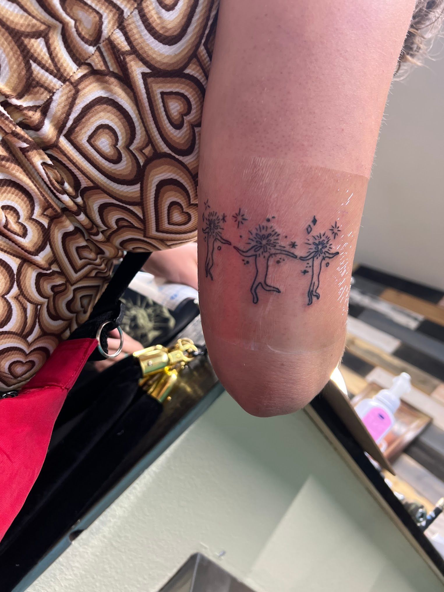 A woman has a tattoo of dandelions on her elbow.