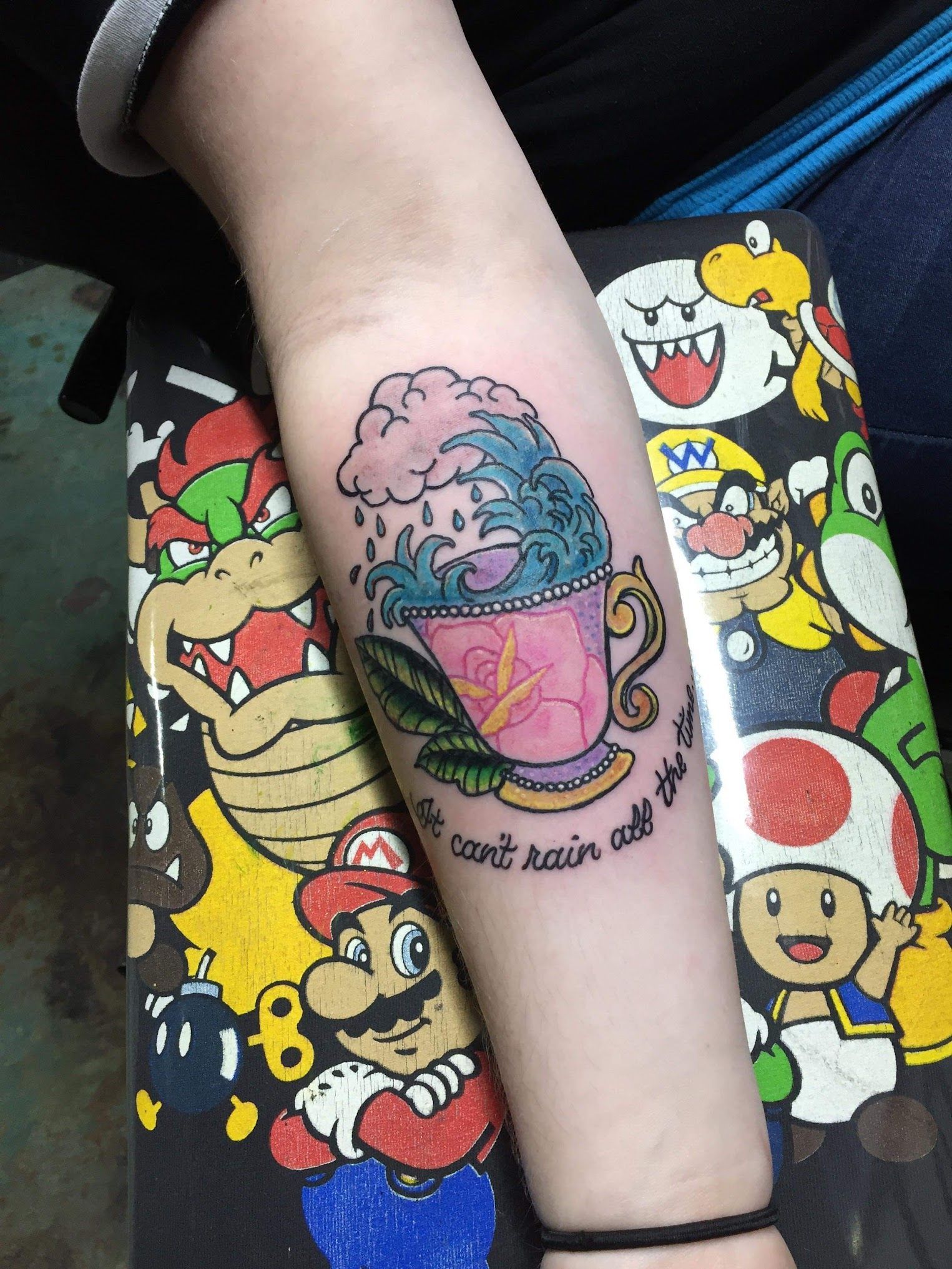 A person has a tattoo of a cup of tea on their arm.