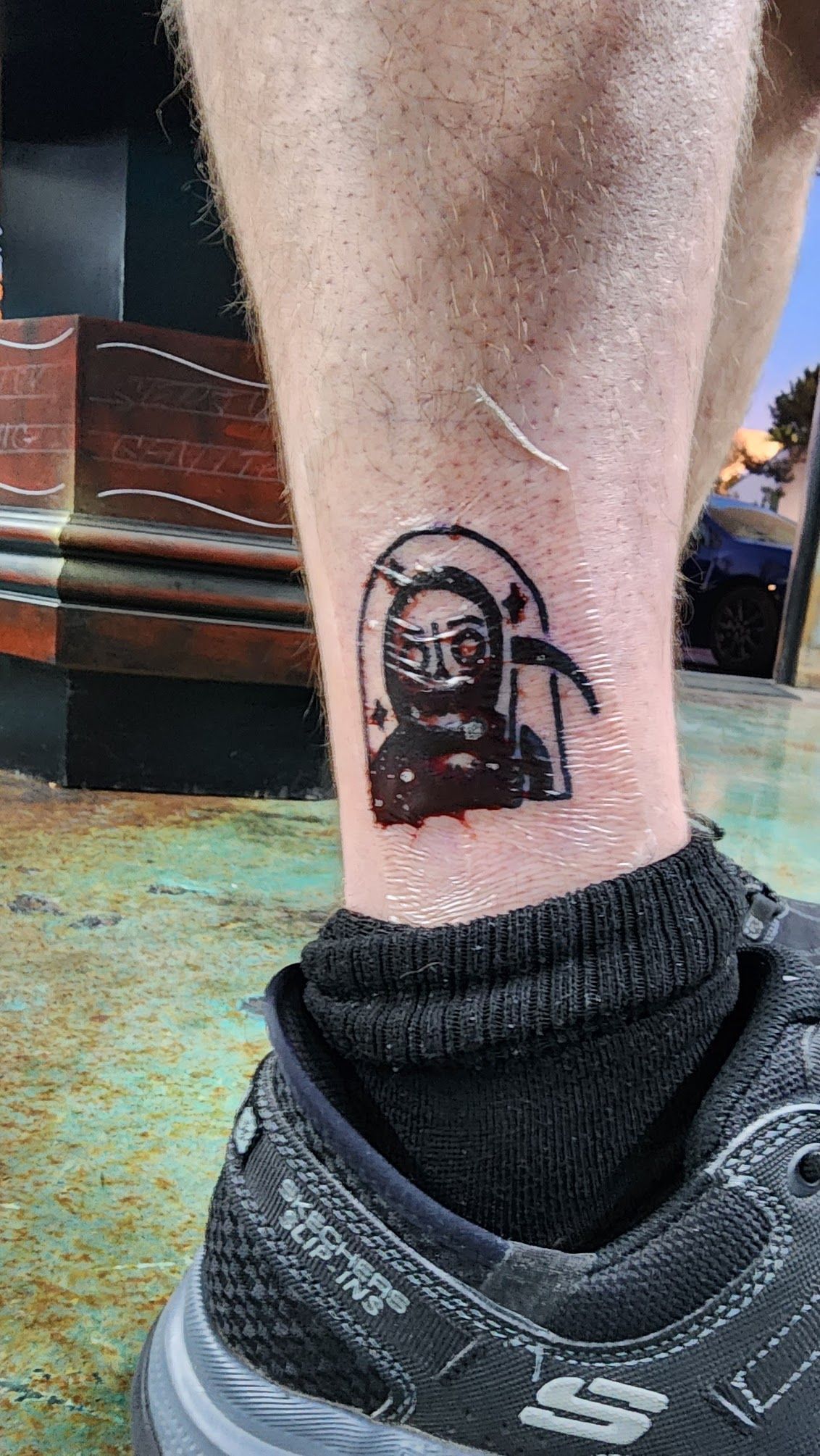 A person has a small tattoo on their ankle.