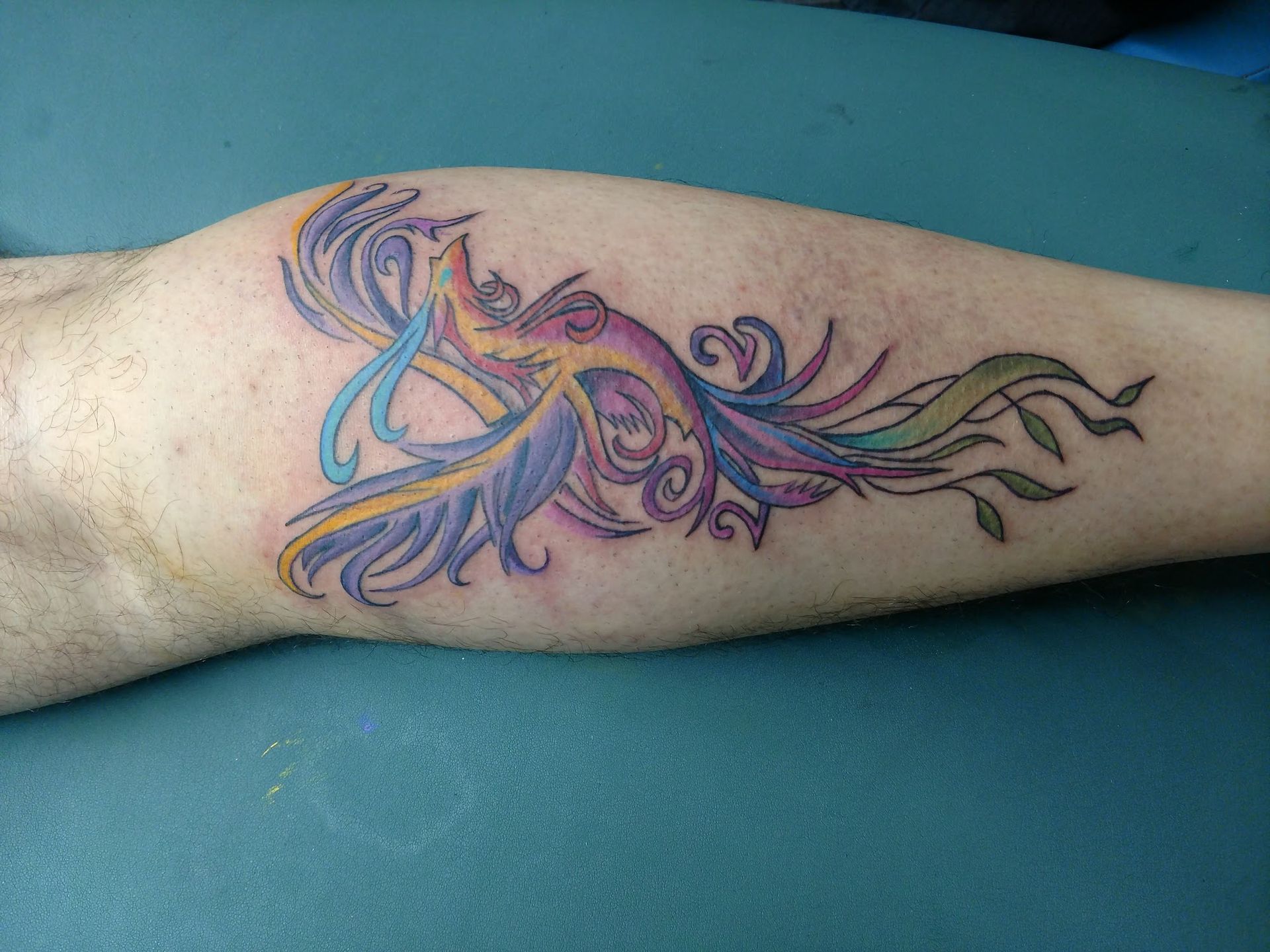 A colorful tattoo of a bird on a person 's arm