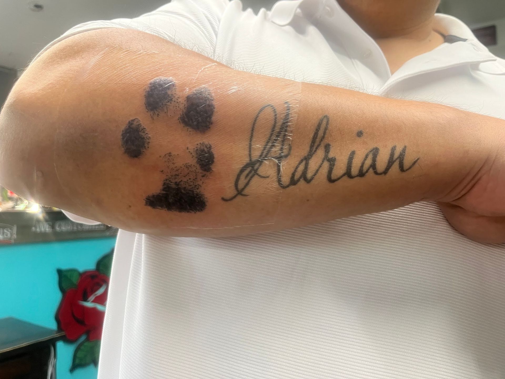 A person has a tattoo of the name adrian on their arm.