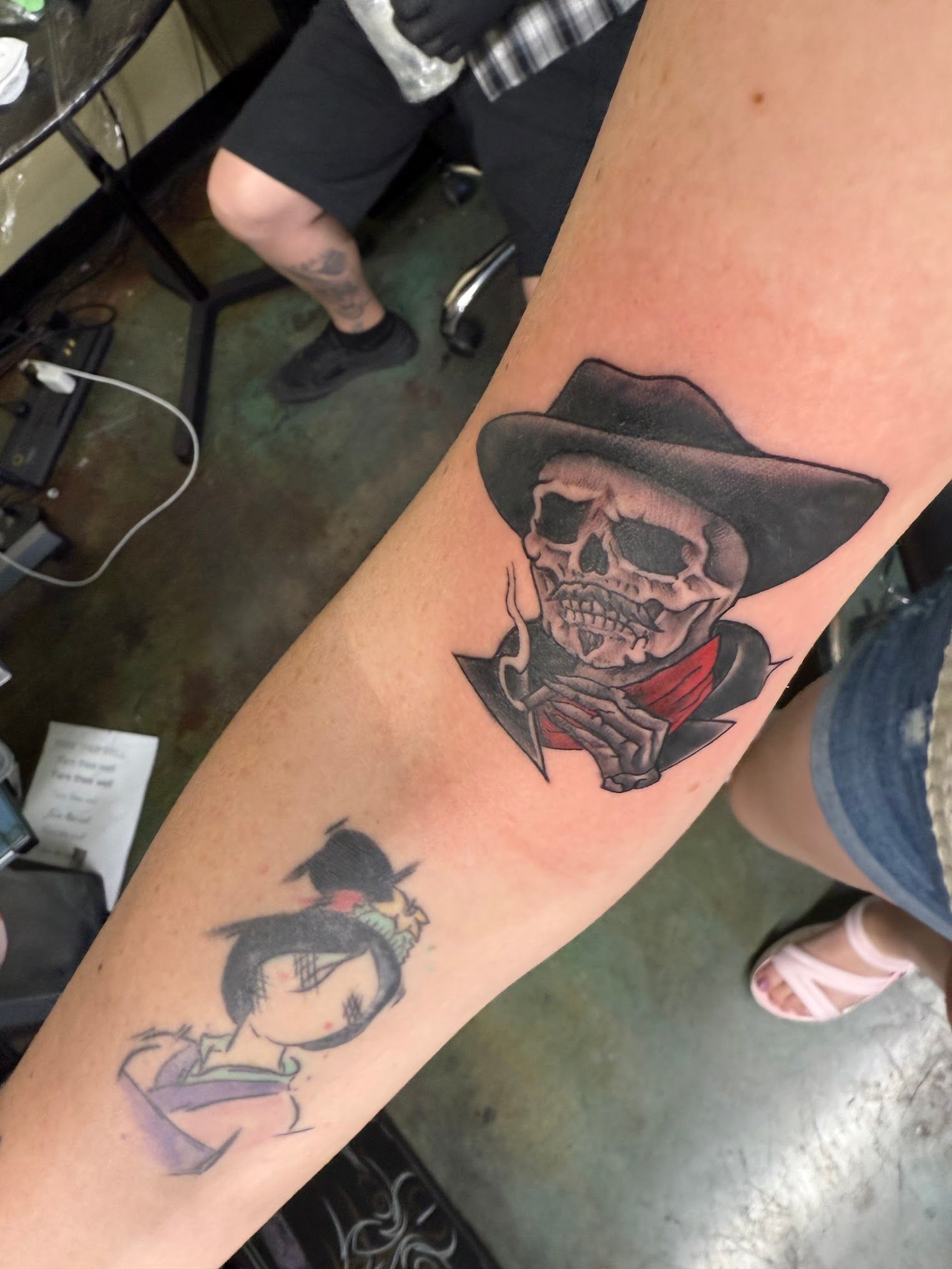 A woman has a tattoo of a skeleton wearing a cowboy hat