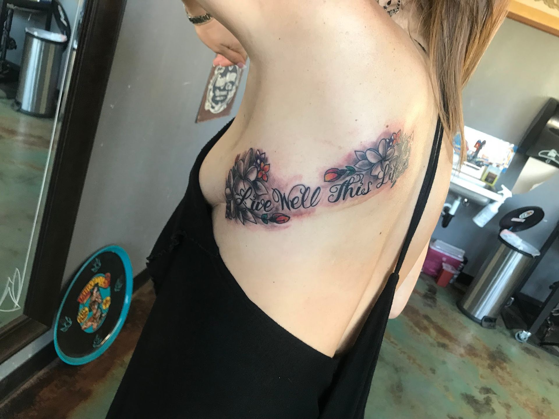 A woman has a tattoo on her side that says 