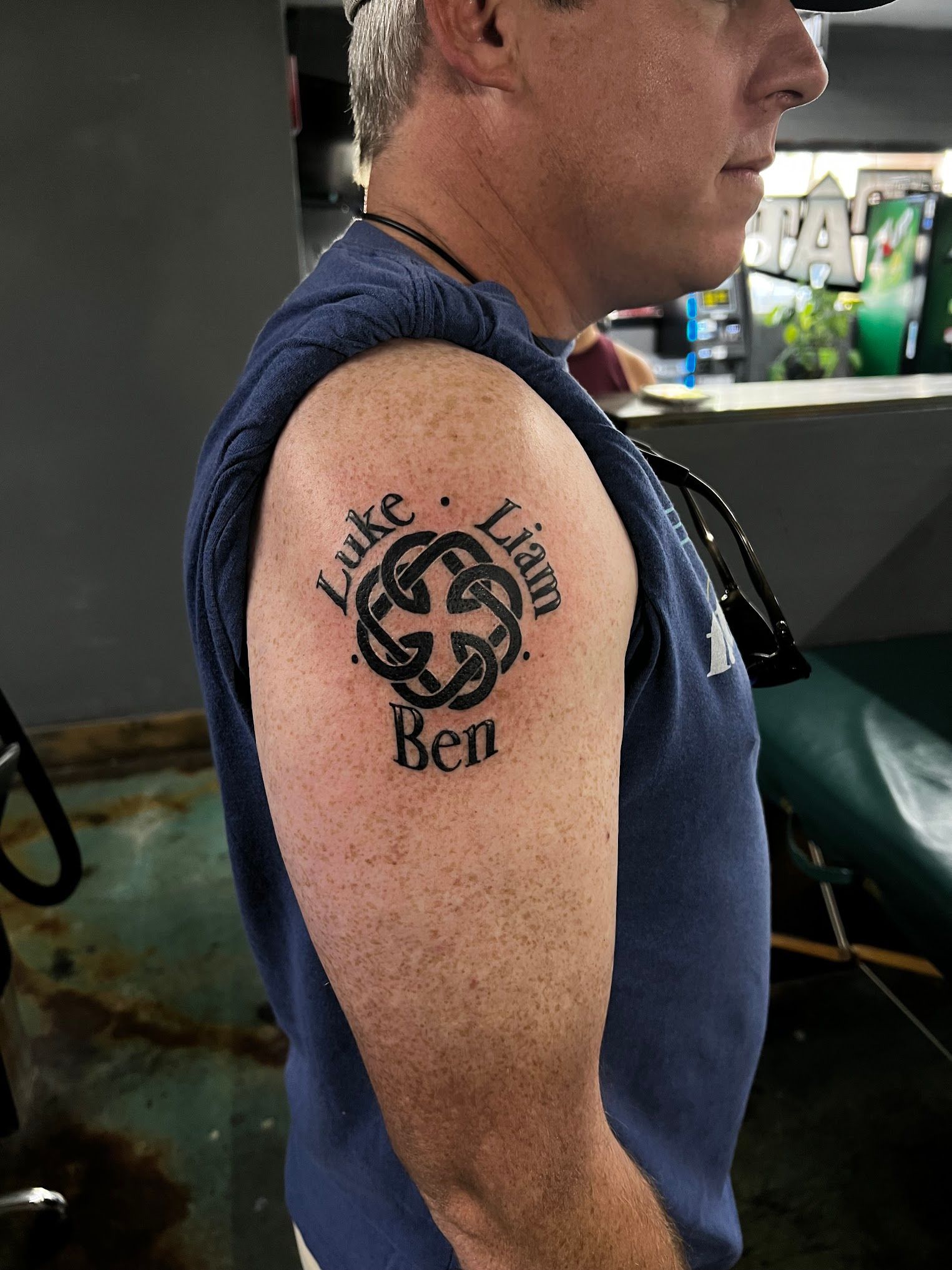 A man has a tattoo on his arm that says luke liam and ben