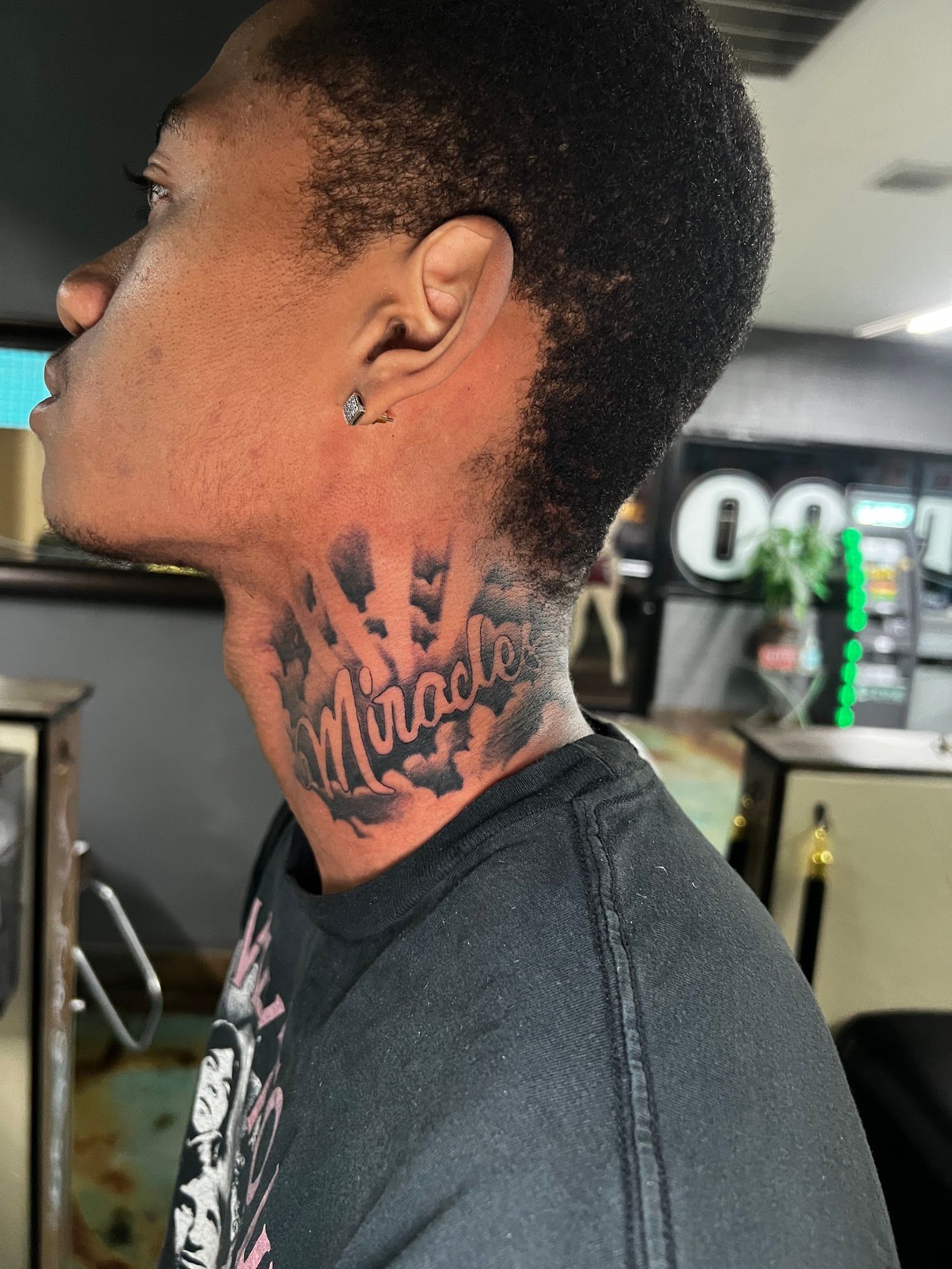 A man has a tattoo on his neck that says miracle