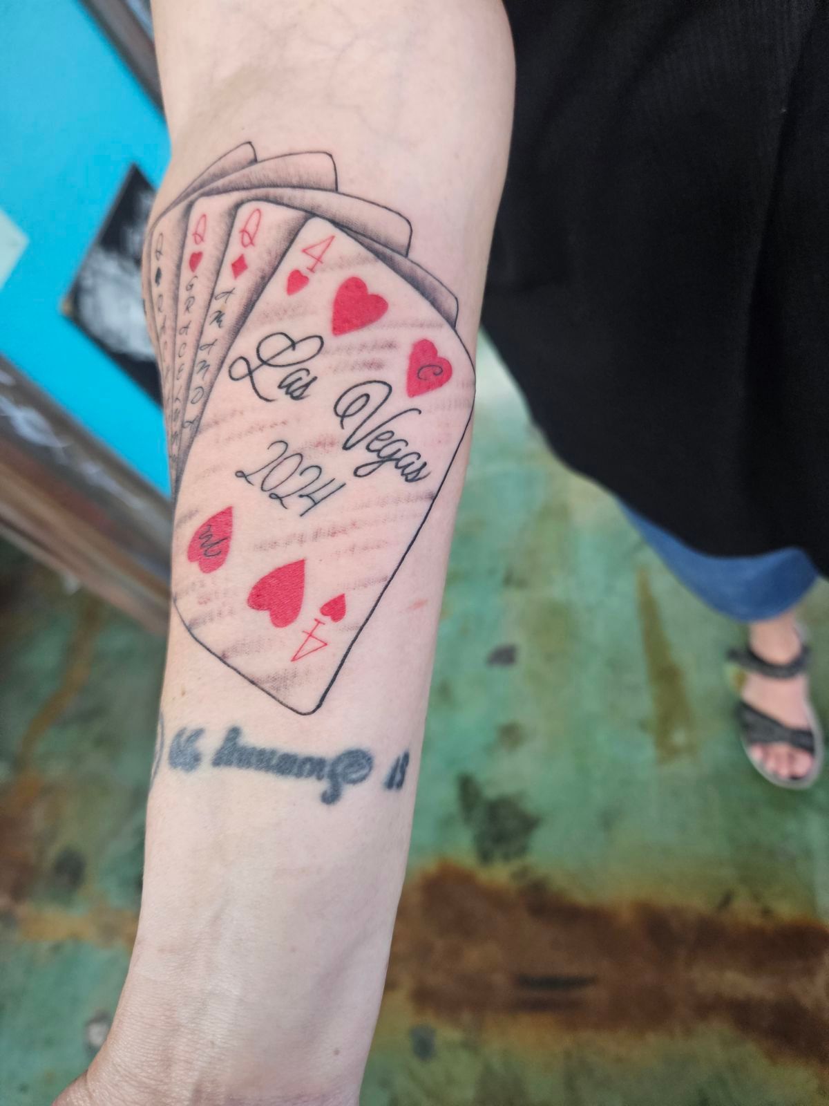 A person has a tattoo of playing cards on their arm