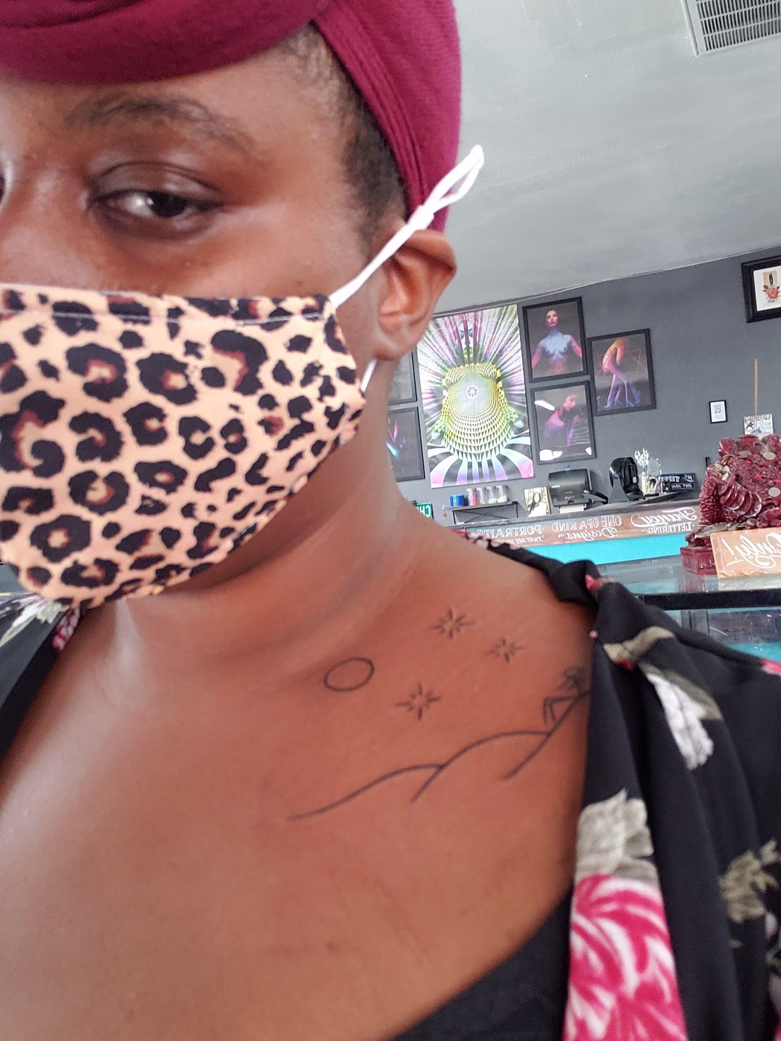 A woman wearing a leopard print mask has a tattoo on her chest