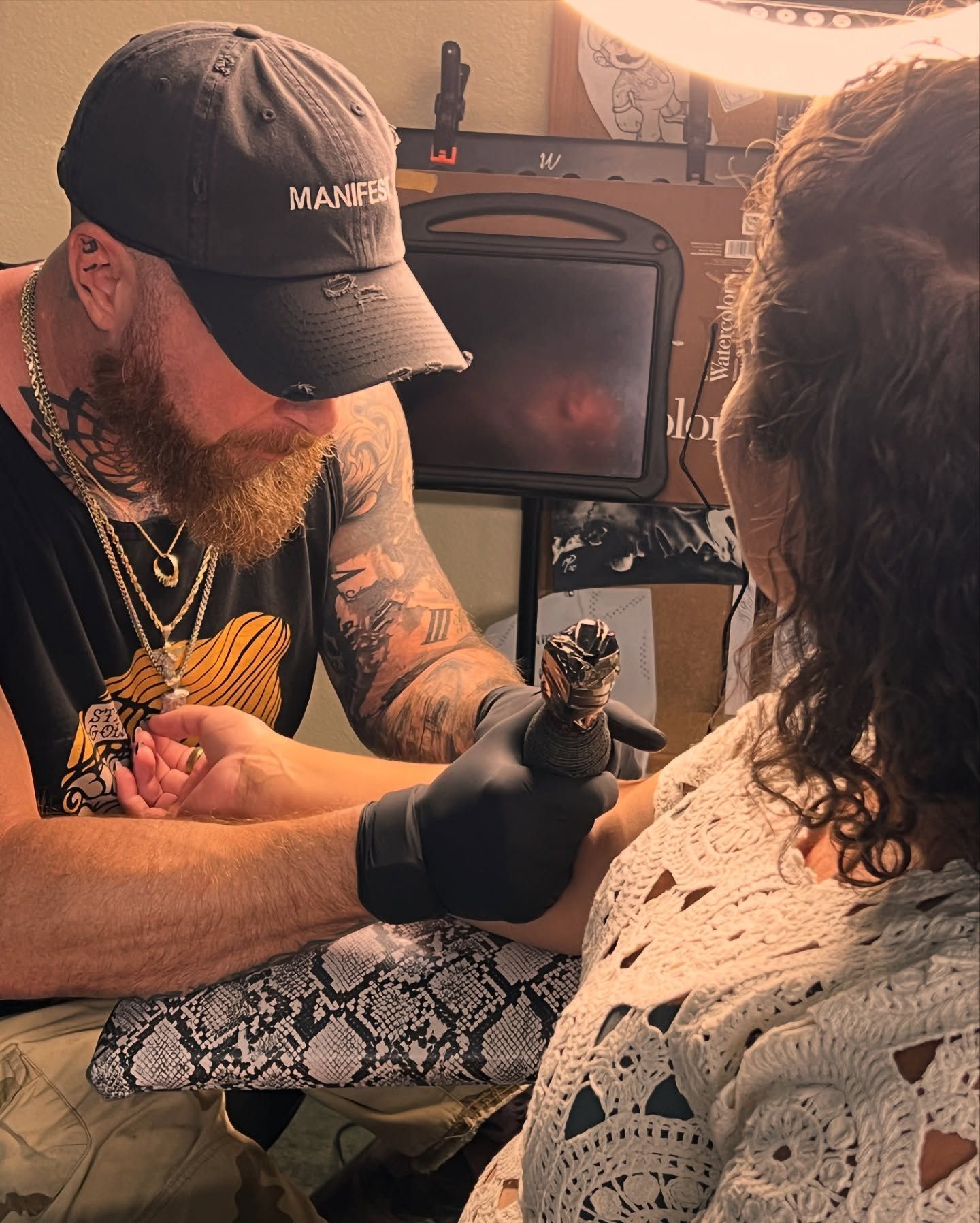 A man is getting a tattoo on a woman 's arm