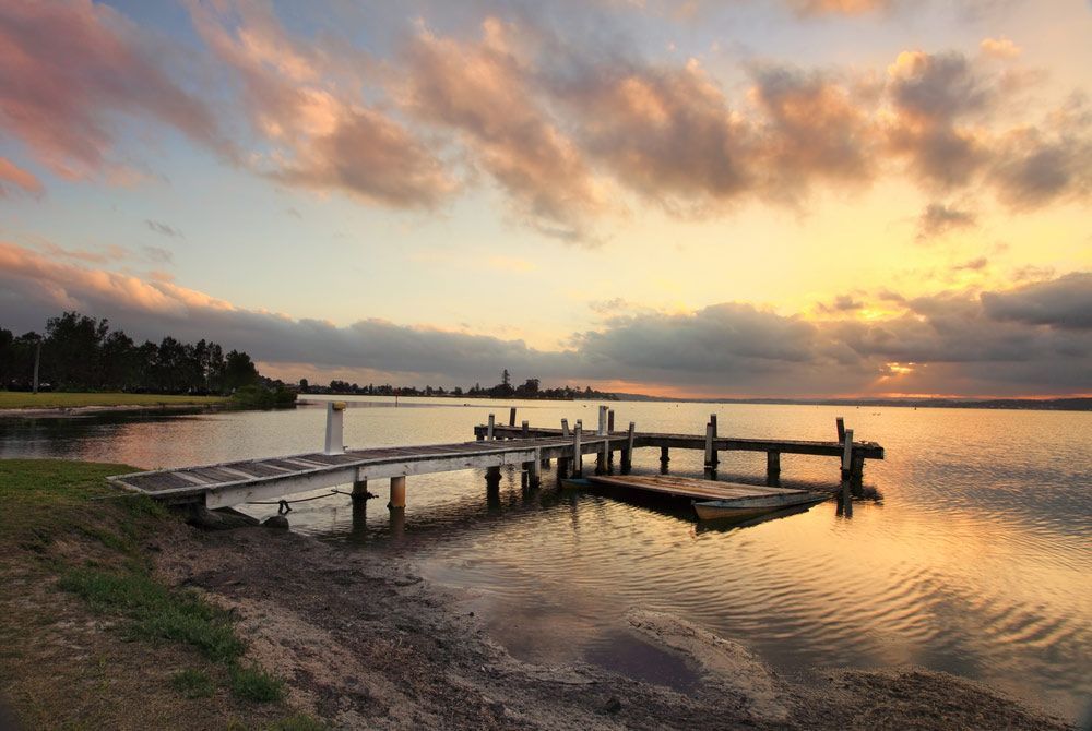 A Wooden Dock In The Middle Of A Lake At Sunset — Smith Aluminium In Belmont, NSW