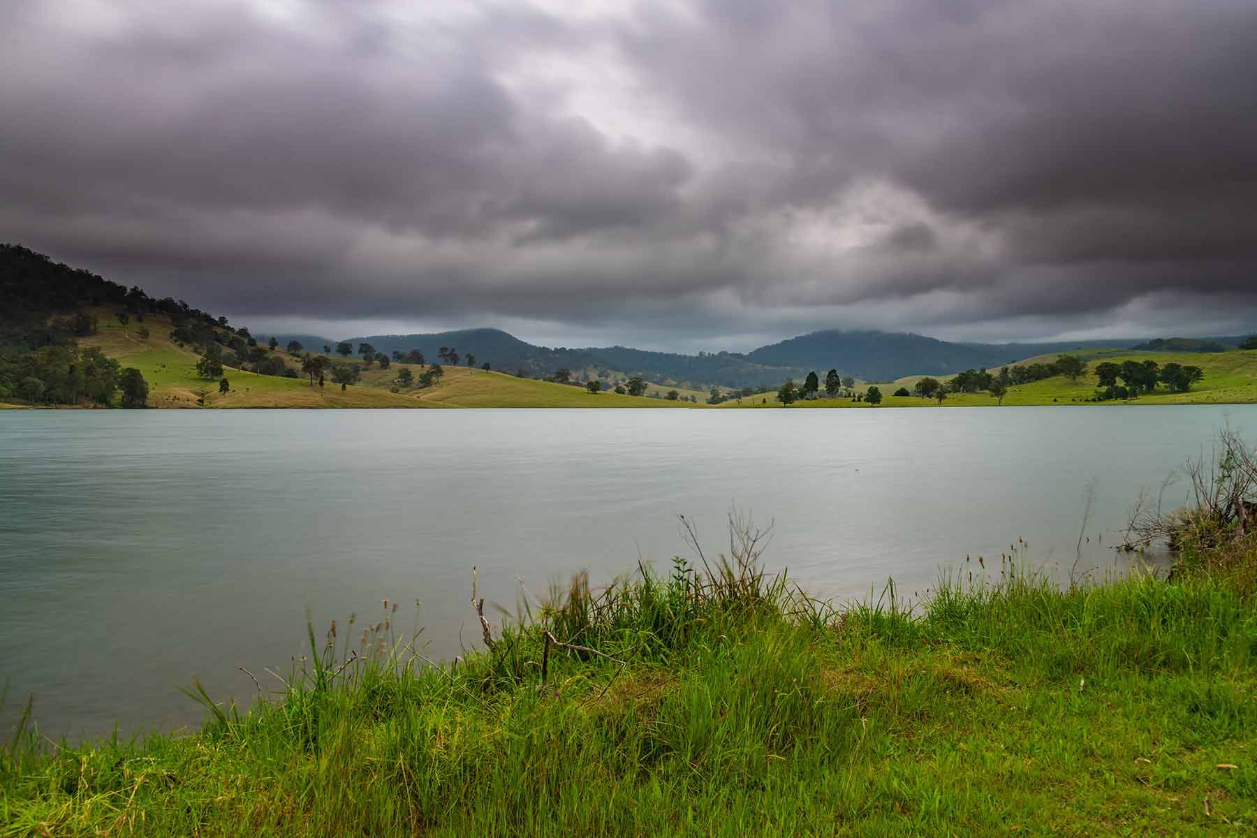 A Lake With Mountains In The Background And A Cloudy Sky — Smith Aluminium In Dungog, NSW