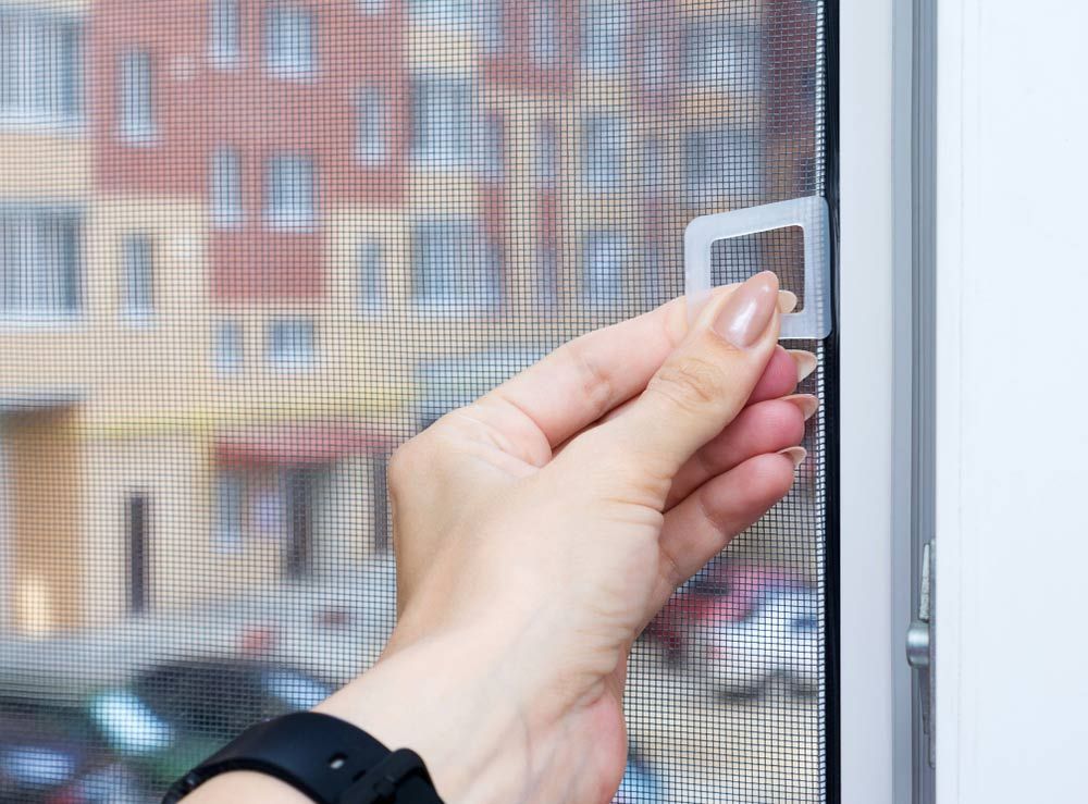 A Person Is Installing A Window Screen — Smith Aluminium In Hawks Nest, NSW