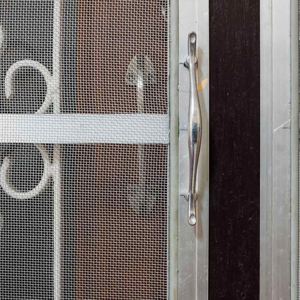 A Close Up Of A Metal Screen Door With A Handle — Smith Aluminium In Cardiff, NSW