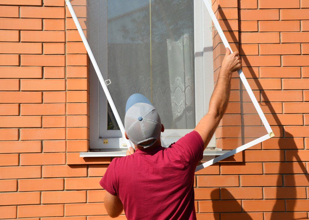 Worker Is Installing A Window Flyscreen — Smith Aluminium In Maitland, NSW