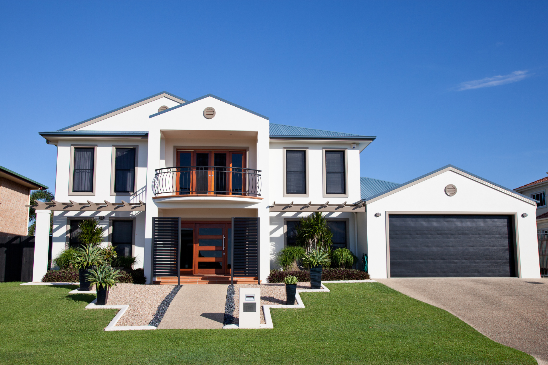 A large white house with a black garage door