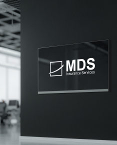 MDS Insurance Services sign mounted on a black wall in an office setting.