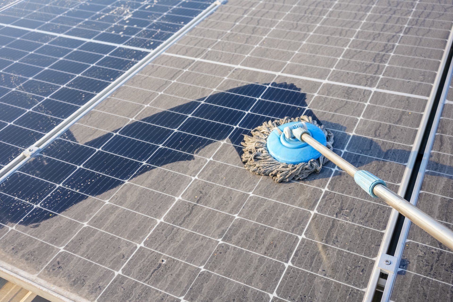 wiping solar panel with a mop