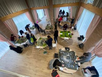 Persona che lava il pavimento con uno straccio blu, un liquido detergente verde e schiuma bianca sul pavimento.