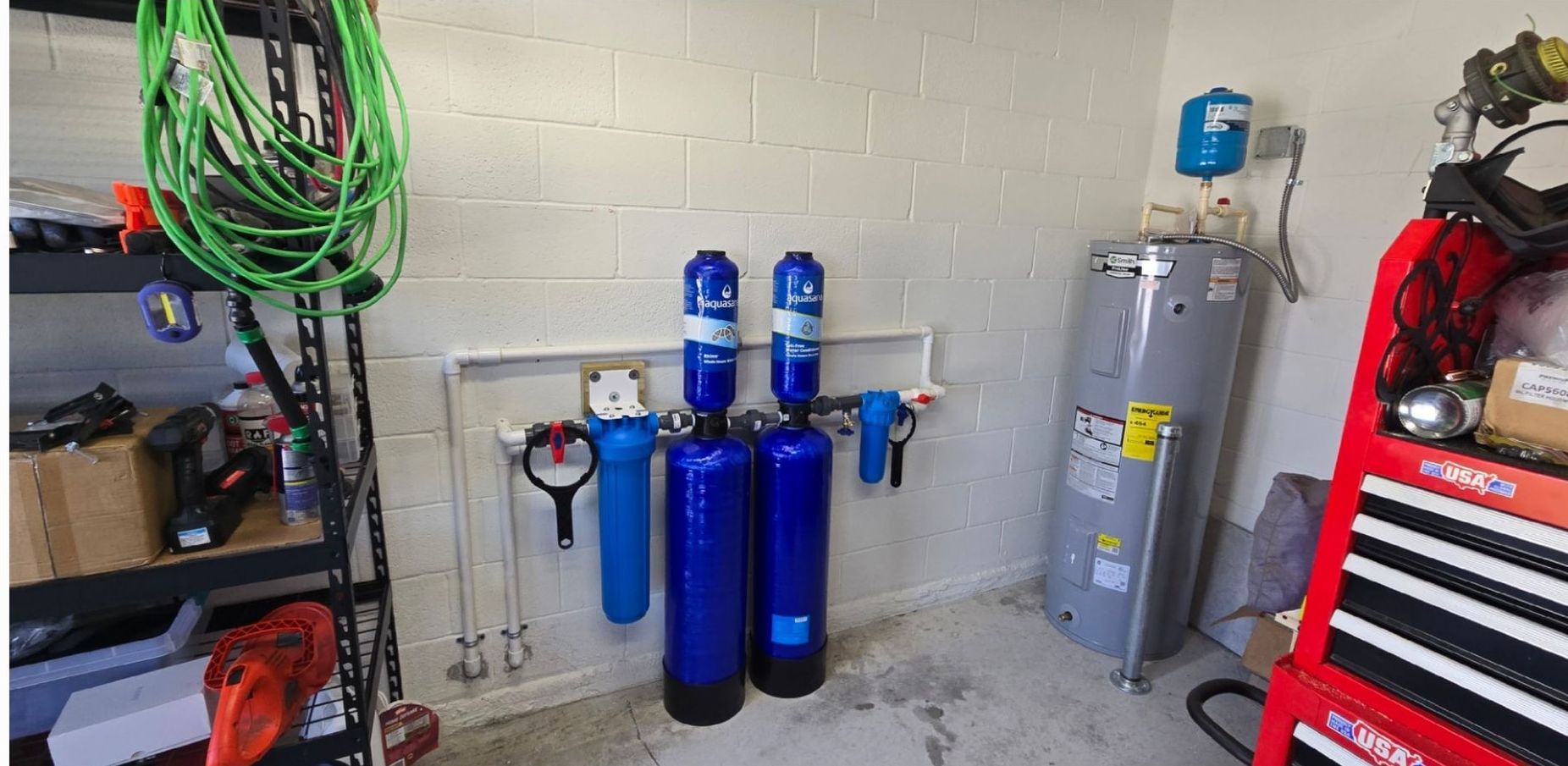 A garage with a water heater and a water filter.