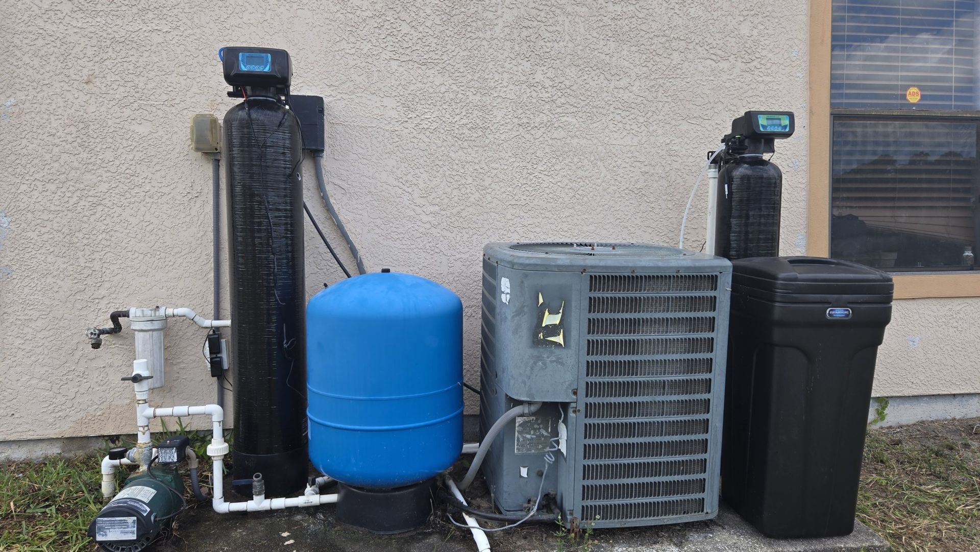 A water treatment system is sitting on the side of a building.