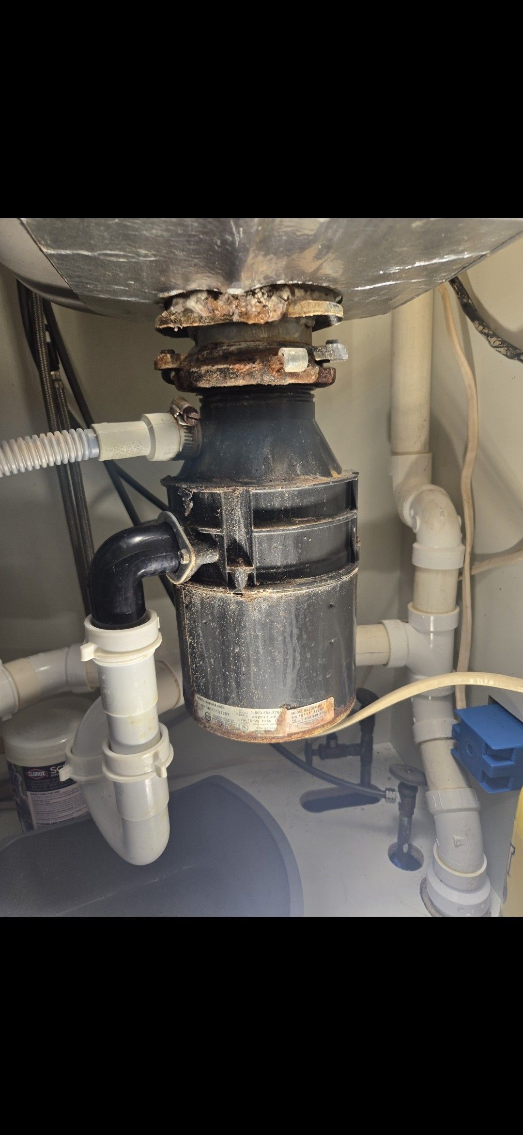A garbage disposal is sitting under a sink in a bathroom.