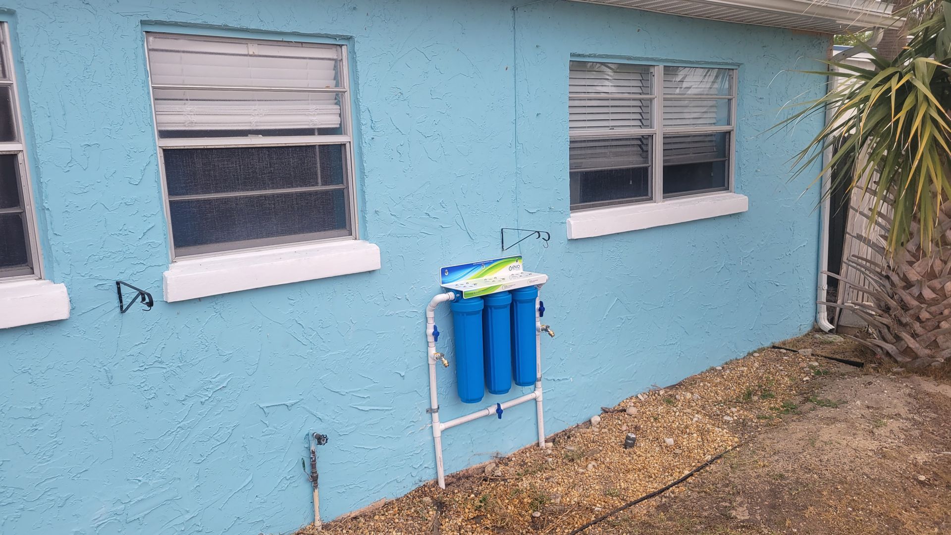A water heater is sitting in a garage next to a wall.