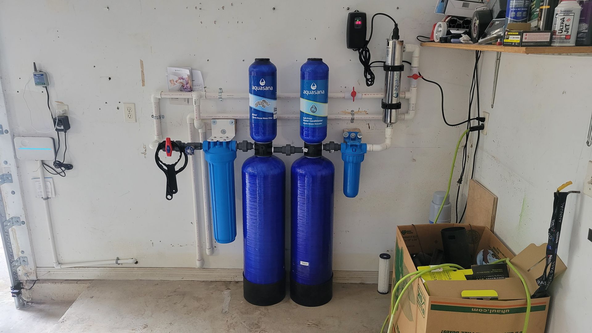 Two blue water filters are sitting next to each other in a garage.