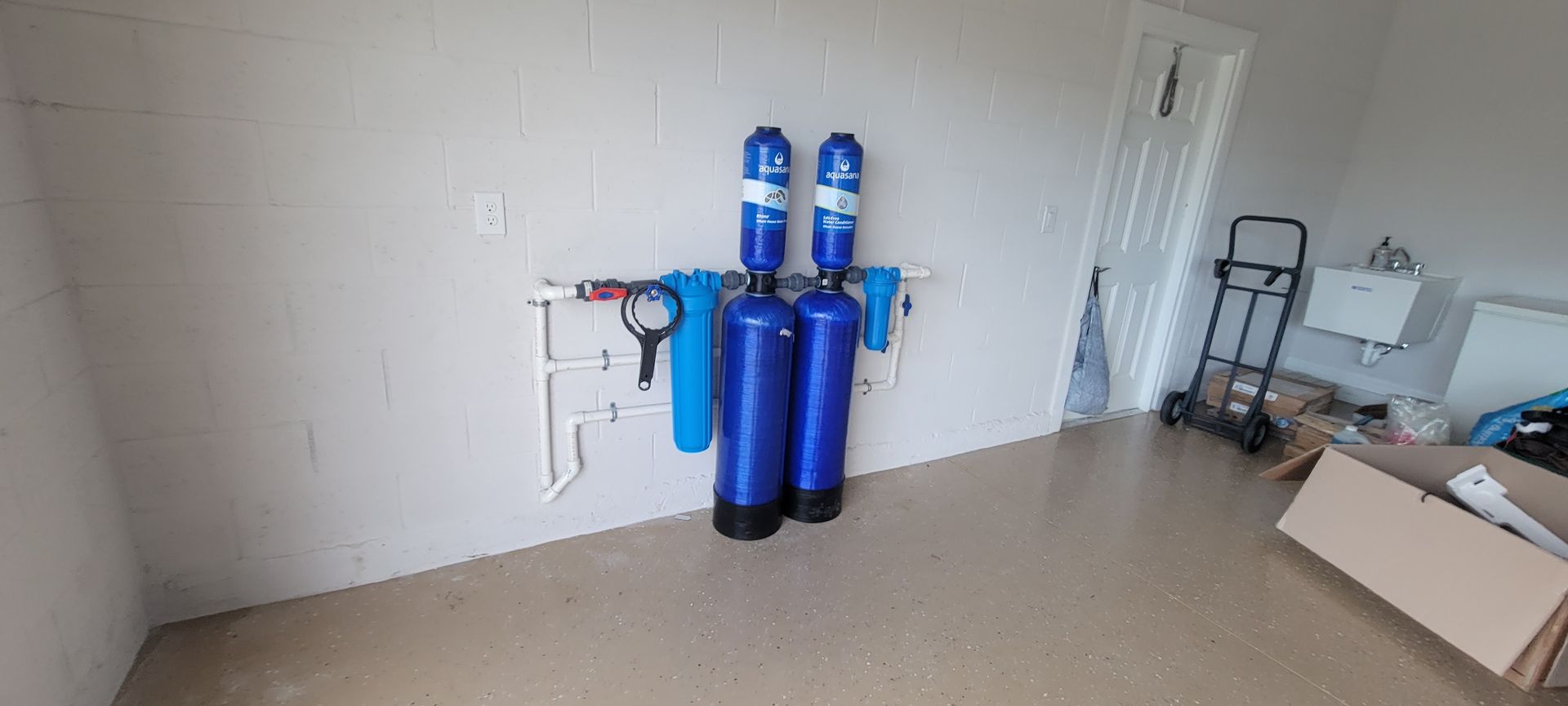 There are two blue tanks hanging on the wall in a room.