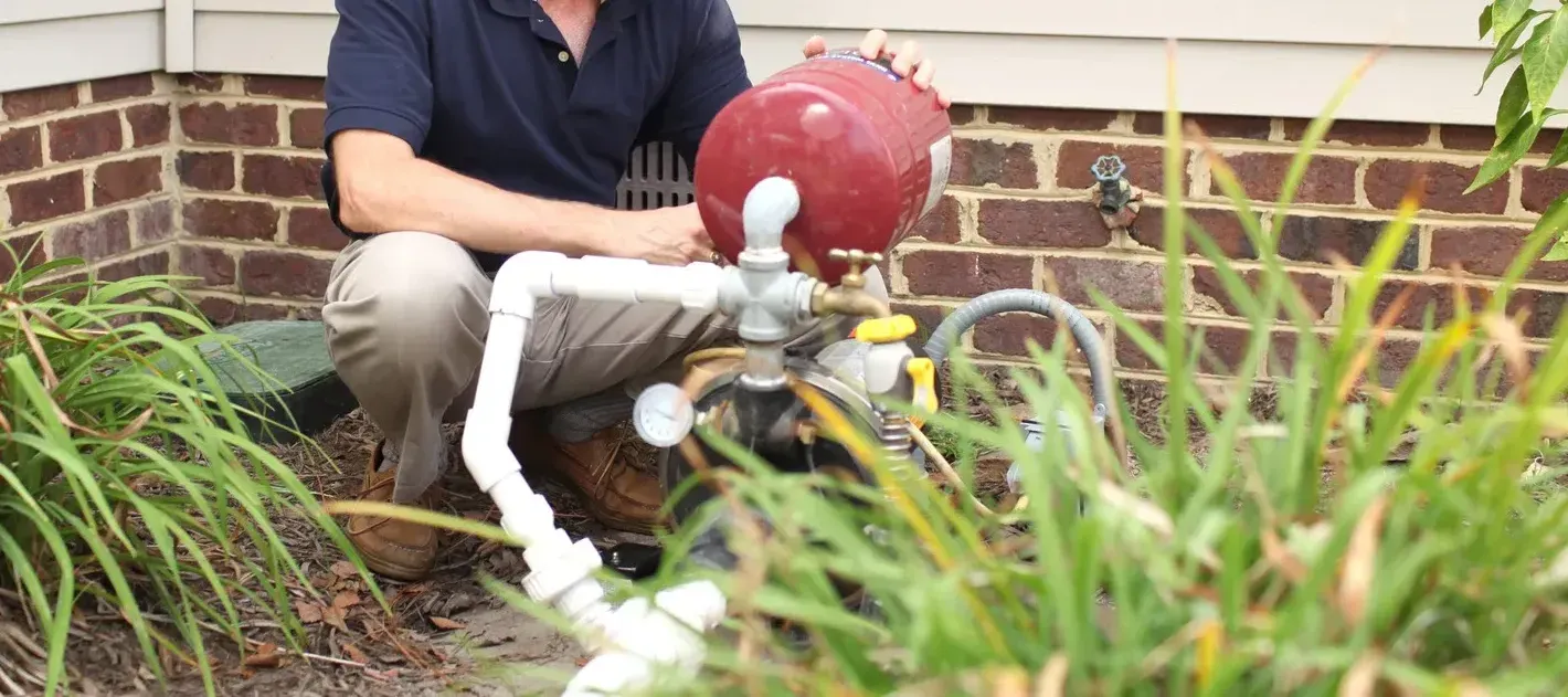 A person is cleaning an air conditioner with their hand.