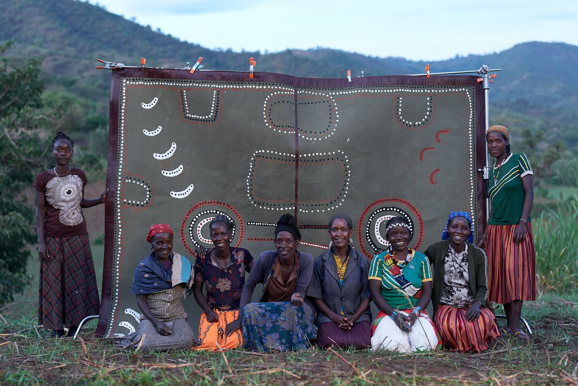 Ari tribe Women posing for a picture in front of a their artwork.